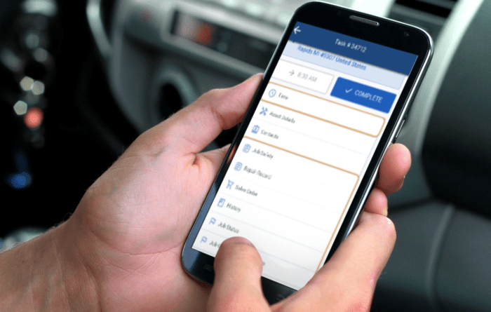 Field technician using NetSuite on a mobile device to access work orders and report service updates.