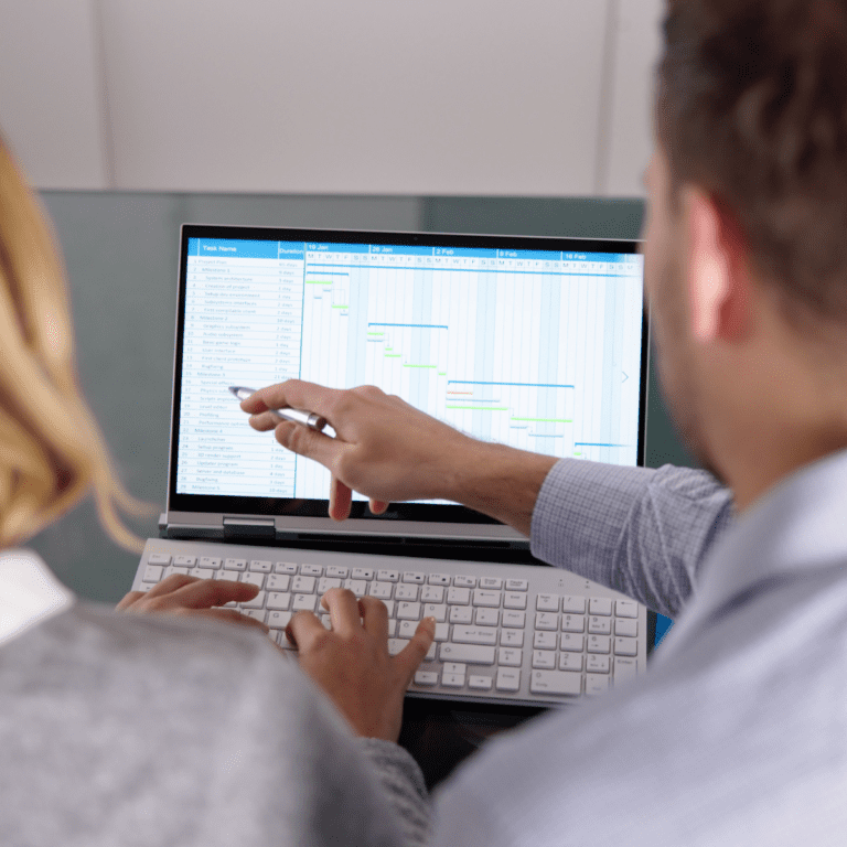 Medarbetare analyserar KPI:er för tillverkning i ett affärssystem med fokus på prognosprecision och lagerstyrning.