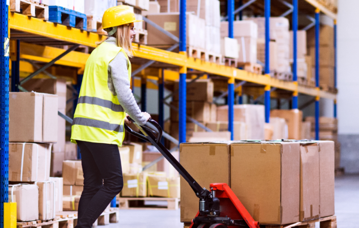 Medarbetare packar en kundorder i ett lager medan NetSuite används för att hantera order, lager och leveranser i en distributionsverksamhet.